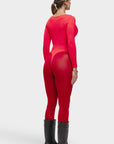 Person wearing a red outfit with sheer panels on a white background