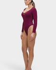 Woman wearing a burgundy bodysuit on a white background