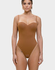 Woman wearing a brown bodysuit on a white background