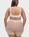Person wearing a beige shapewear garment on a white background