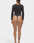 Person wearing a black bodysuit on a white background