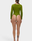 Person wearing a green bodysuit on a white background
