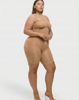 Person wearing a beige bodysuit on a white background