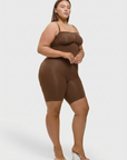 Woman wearing a brown bodysuit on a white background