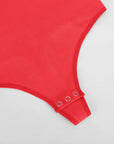 Close-up of a red garment with a ribbed texture on a light gray background