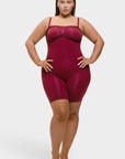 Woman wearing a maroon bodysuit against a white background