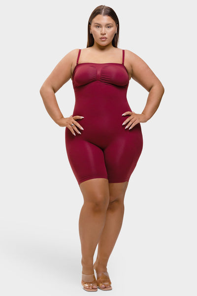 Woman wearing a maroon bodysuit against a white background
