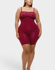 Woman wearing a burgundy bodysuit on a white background