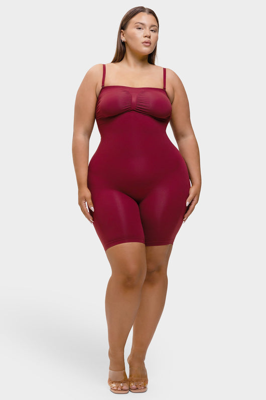 Woman wearing a burgundy bodysuit on a white background