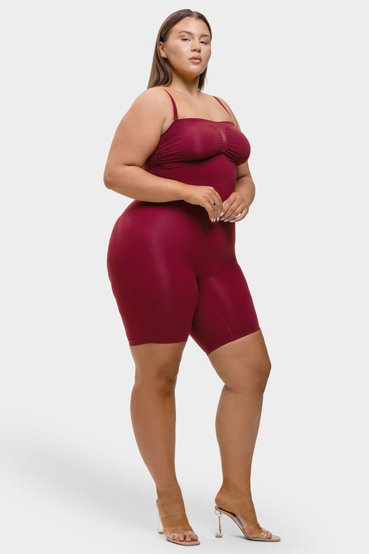 Woman wearing a burgundy romper on a white background