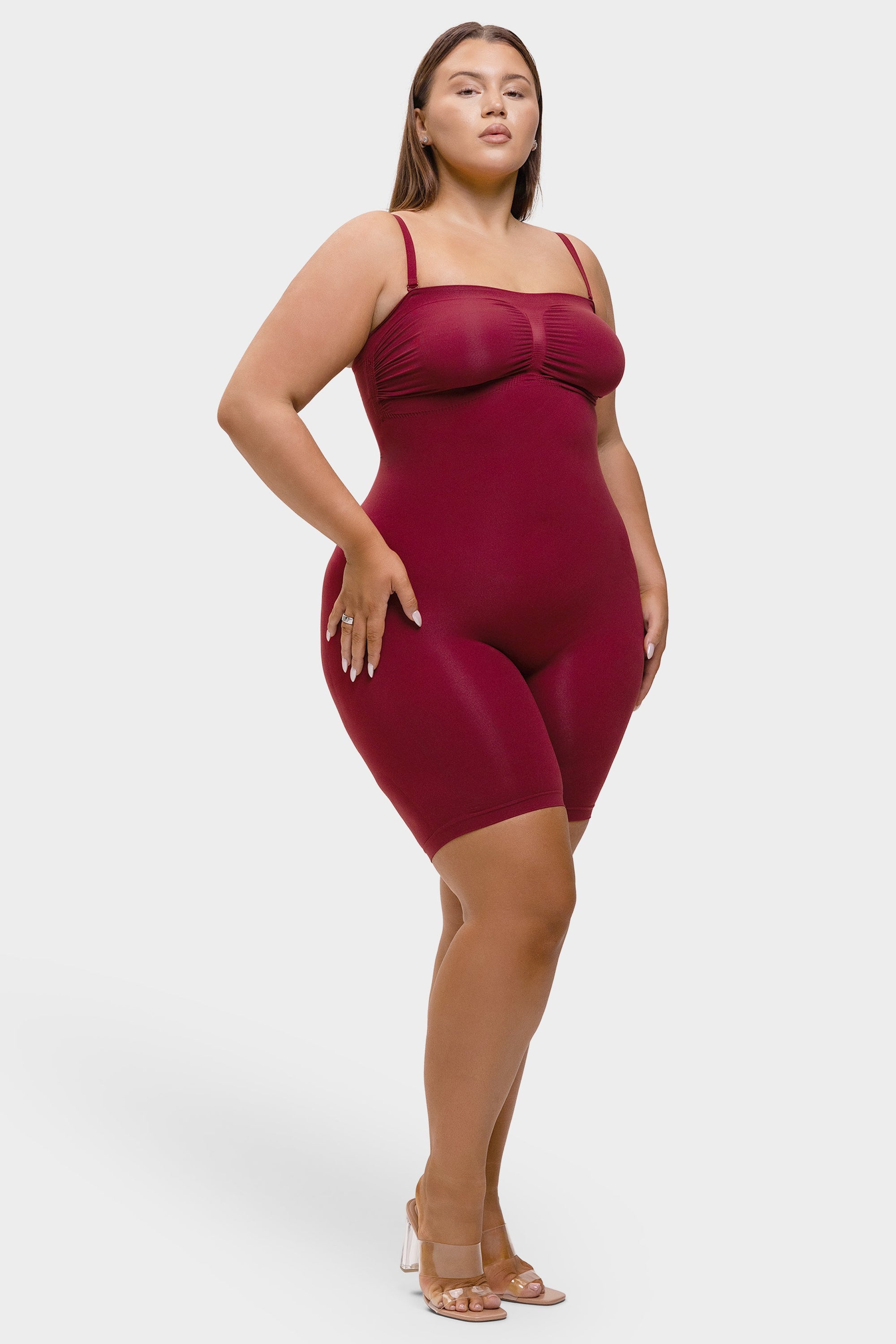 Woman wearing a burgundy swimsuit against a white background
