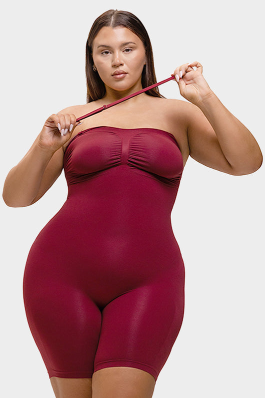 Woman wearing a maroon bodysuit against a white background