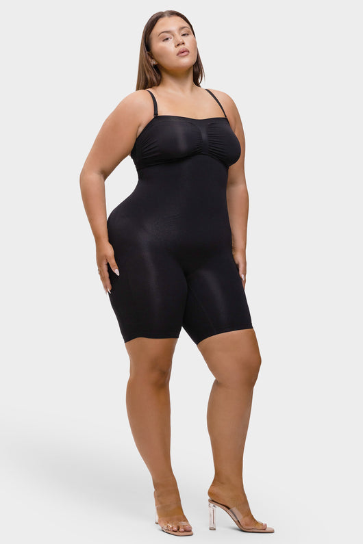 Woman wearing a black bodysuit on a white background