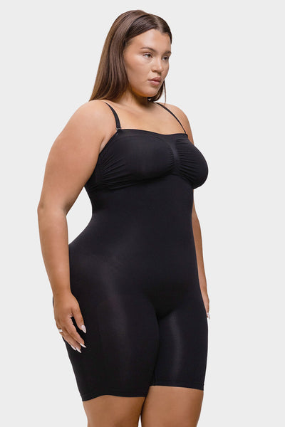 Woman wearing a black shapewear bodysuit on a white background