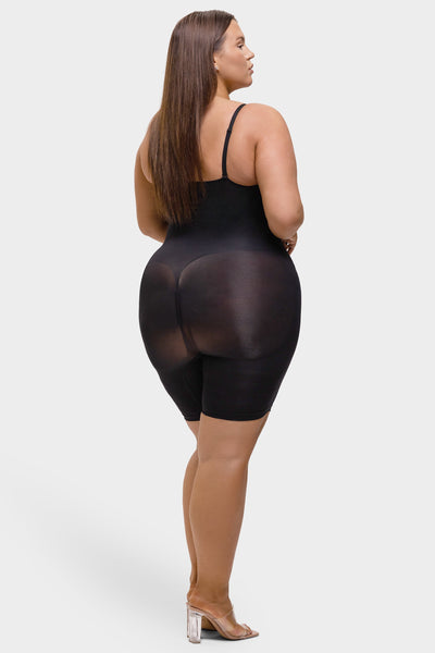 Woman wearing a black sheer romper on a white background