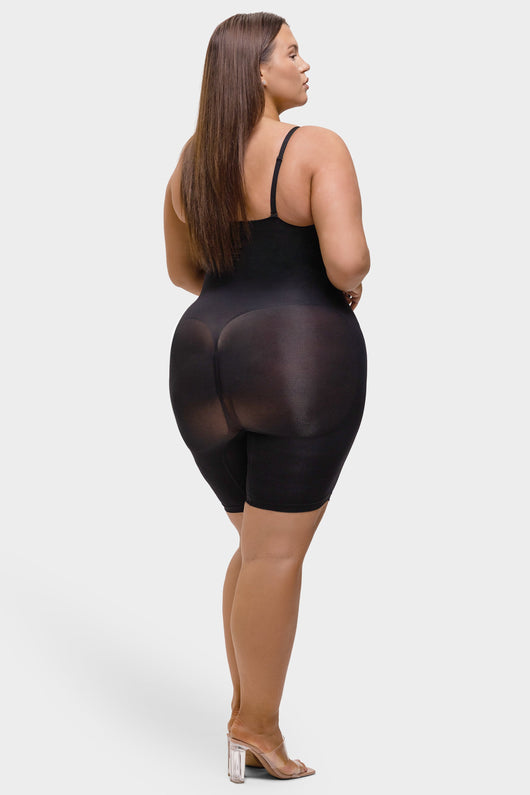 Woman wearing a black sheer romper on a white background