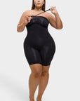 Woman wearing a black bodysuit against a white background