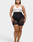 Woman wearing a white top and black sheer shorts on a white background