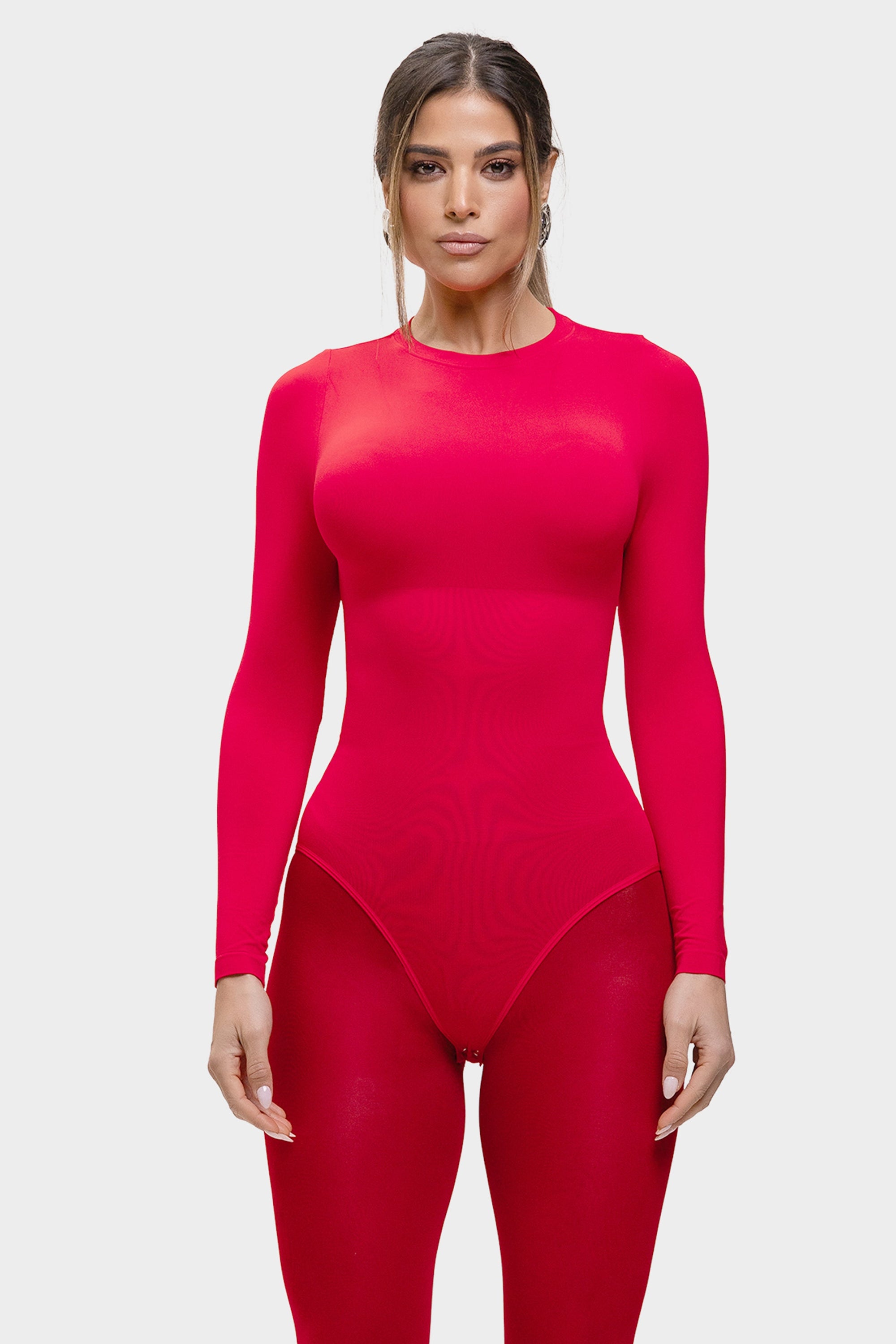 Person wearing a bright pink bodysuit on a light gray background