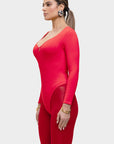 Woman wearing a red outfit with a plunging neckline and long sleeves on a white background