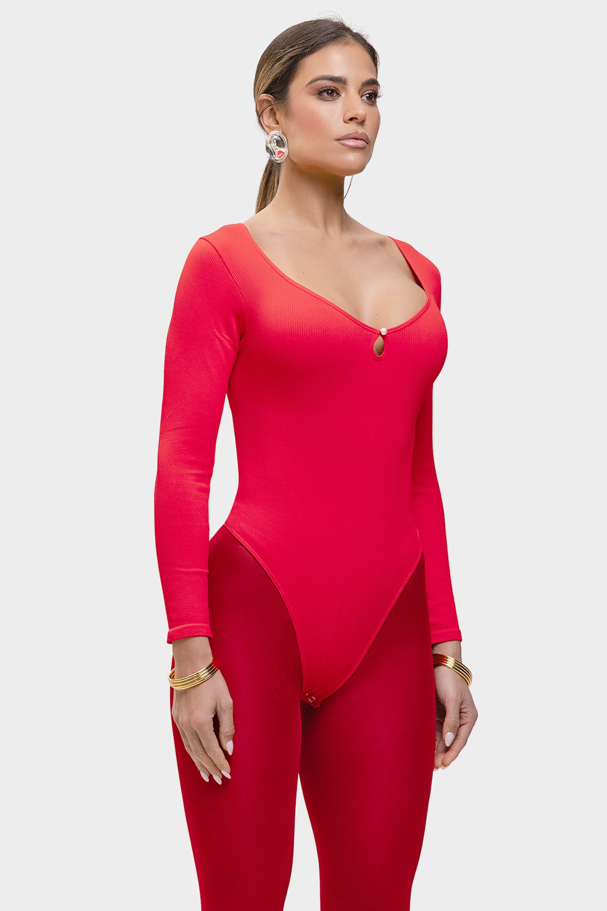 Woman wearing a red bodysuit on a white background