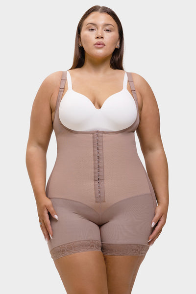 Woman wearing a beige shapewear garment over a white bra on a white background