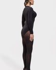 Woman wearing a black bodysuit and stockings on a white background