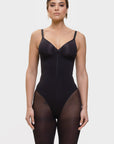 Woman wearing a black bodysuit on a white background
