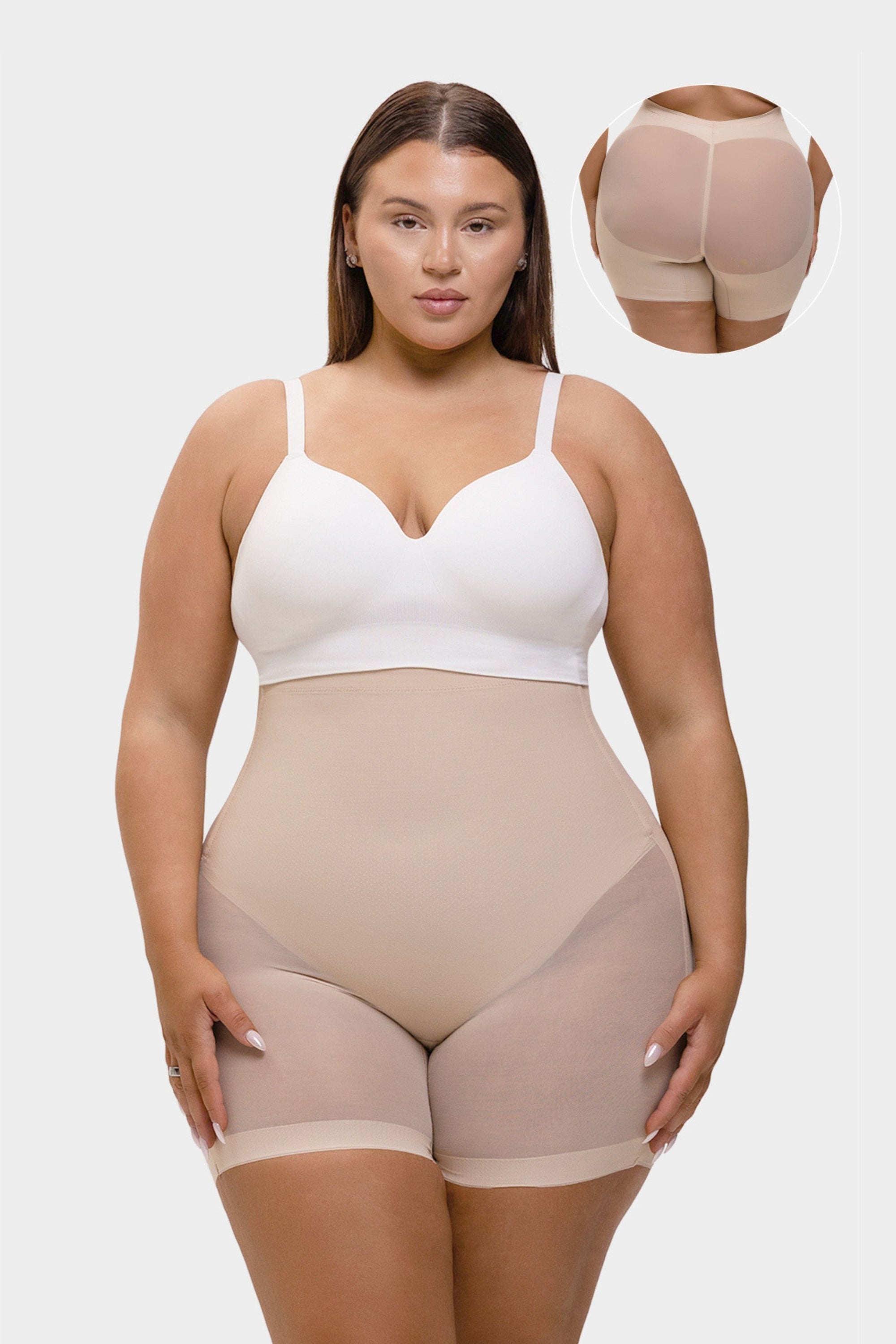 Woman wearing a beige shapewear garment with a white top on a light gray background.