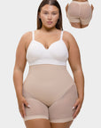 Woman wearing a beige shapewear garment with a white top on a light gray background.