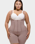 Woman wearing a beige waist trainer over a white top on a plain background