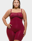 Woman wearing a maroon bodysuit against a white background