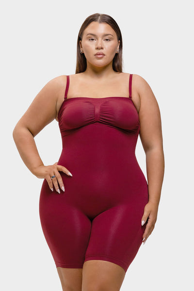 Woman wearing a maroon bodysuit against a white background