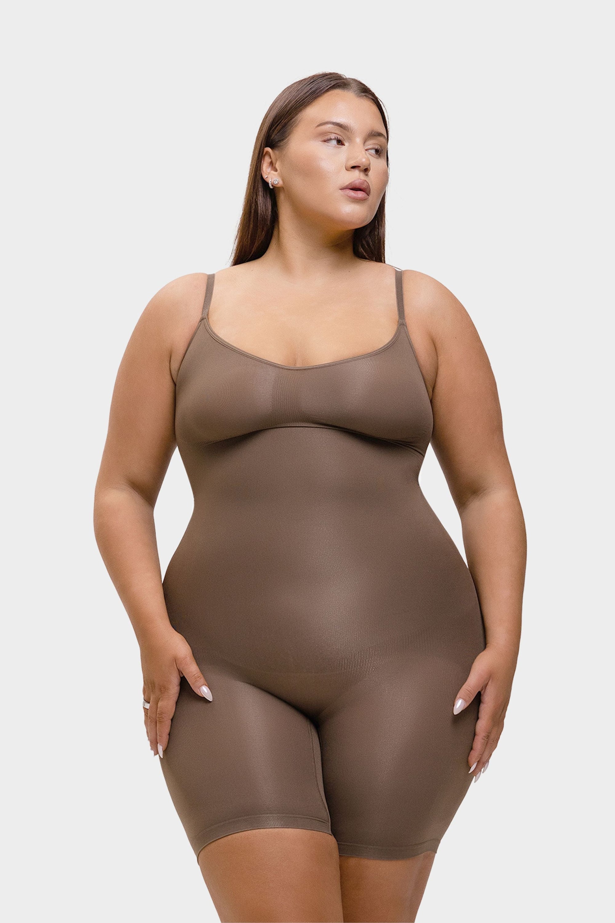 Woman wearing a brown shapewear bodysuit on a white background