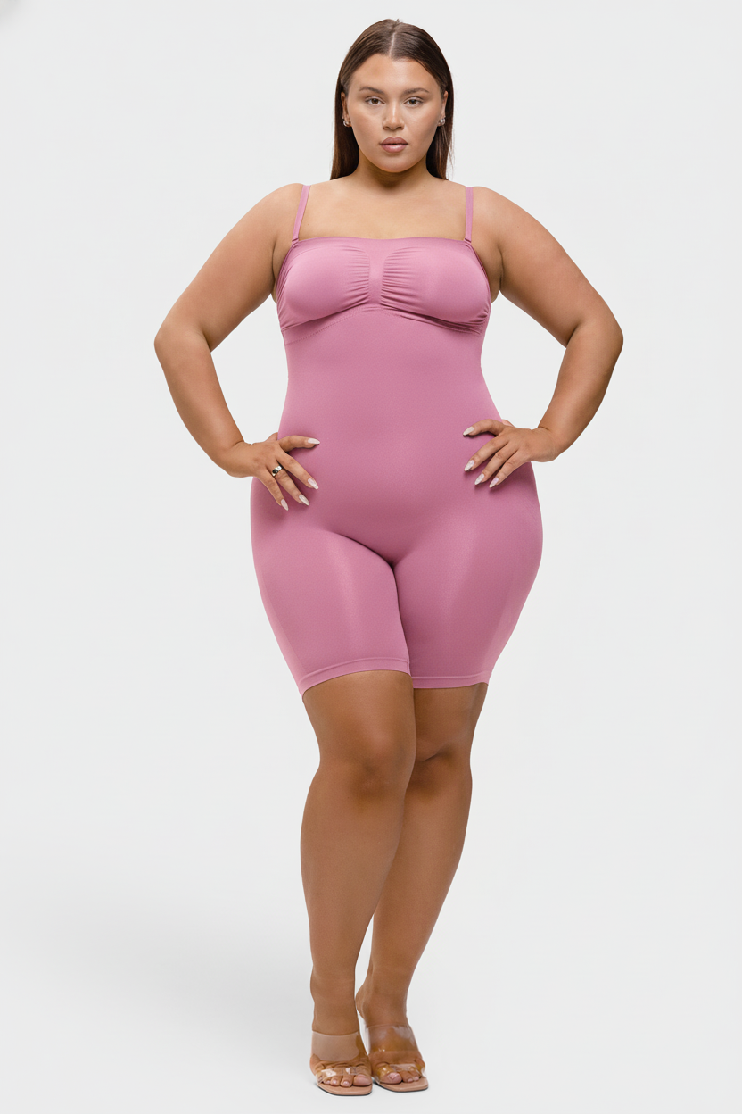 Woman wearing a pink bodysuit against a white background