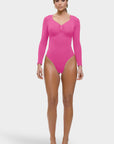 Woman wearing a bright pink bodysuit on a white background