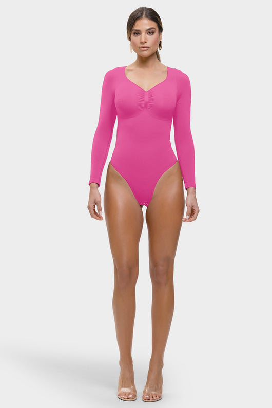 Woman wearing a bright pink bodysuit on a white background