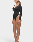 Woman wearing a black bodysuit with long sleeves on a white background