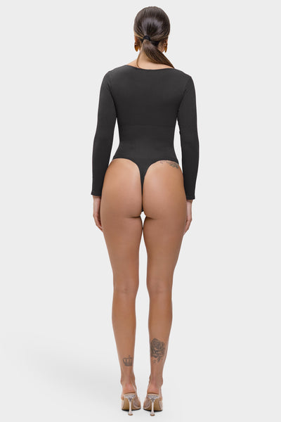 Person wearing a black bodysuit on a white background