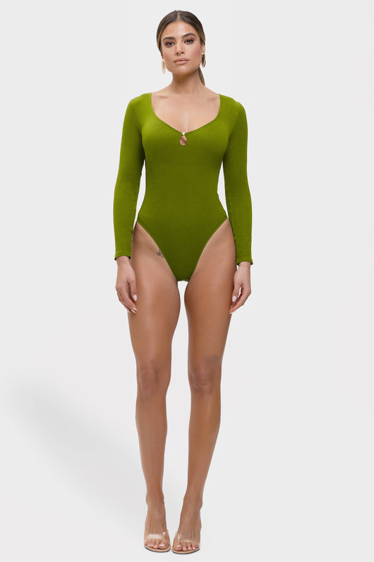 Woman wearing a green swimsuit with long sleeves on a white background