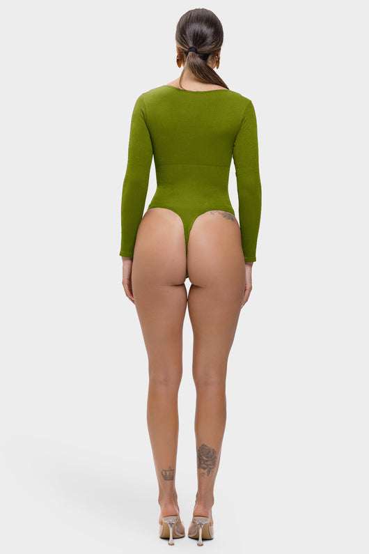 Person wearing a green bodysuit on a white background