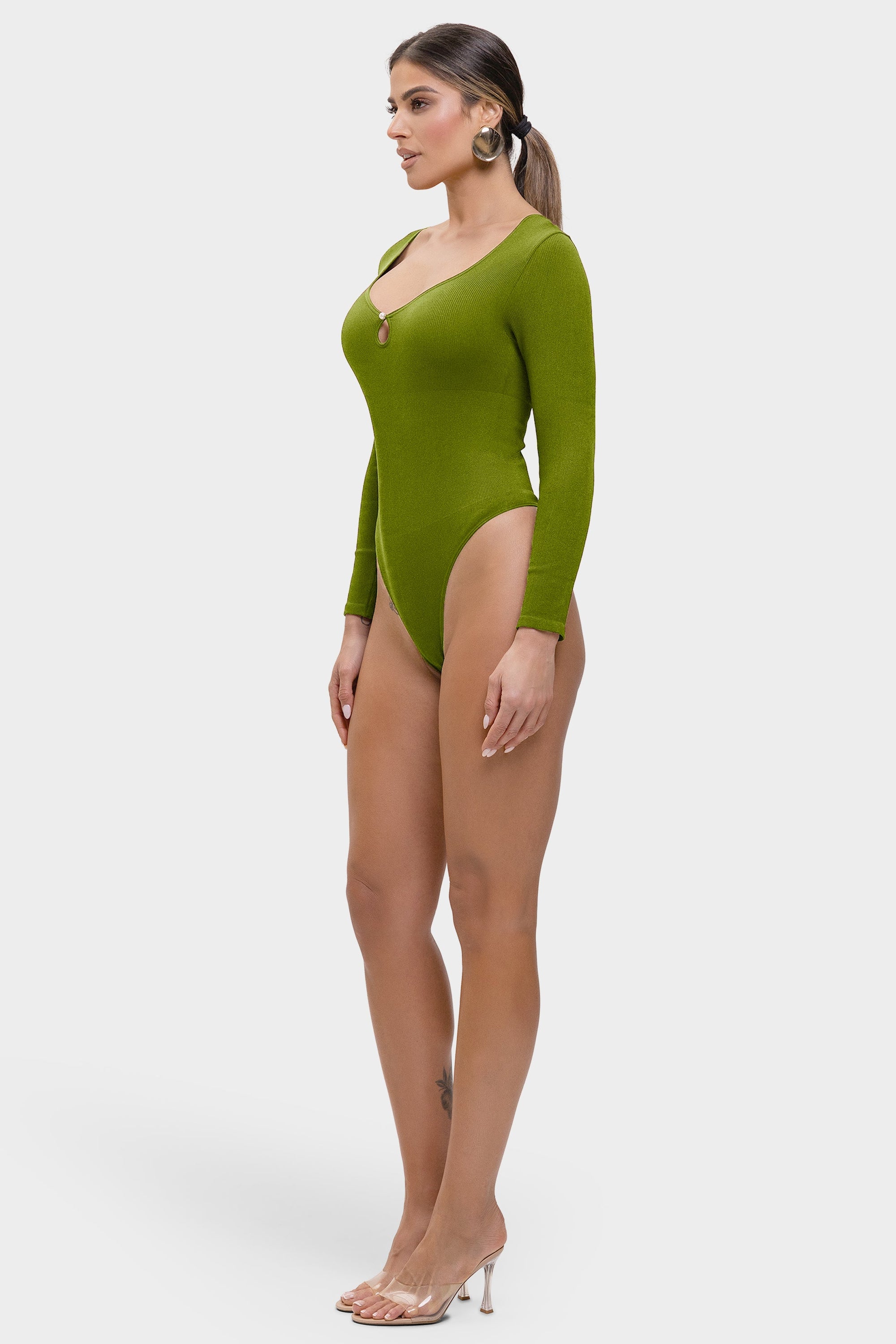 Woman wearing a green bodysuit on a white background