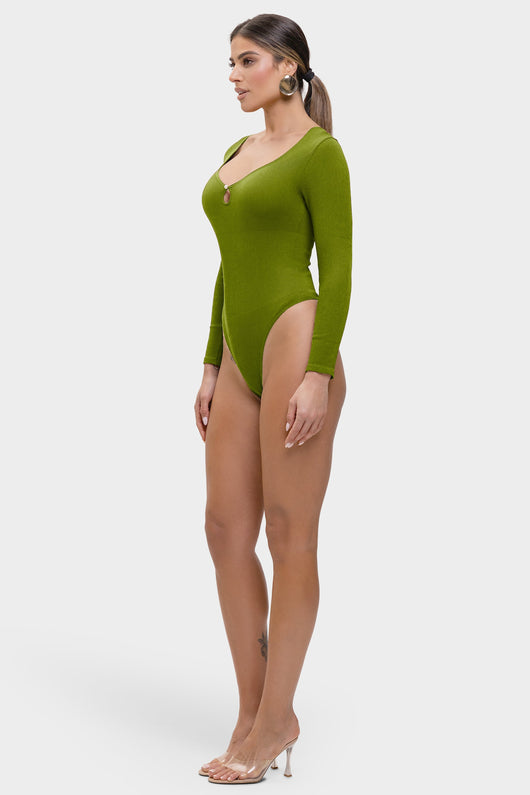 Woman wearing a green bodysuit on a white background