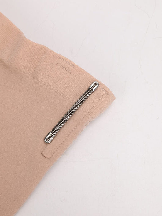 Close-up of beige shorts with a zipper on a light gray background